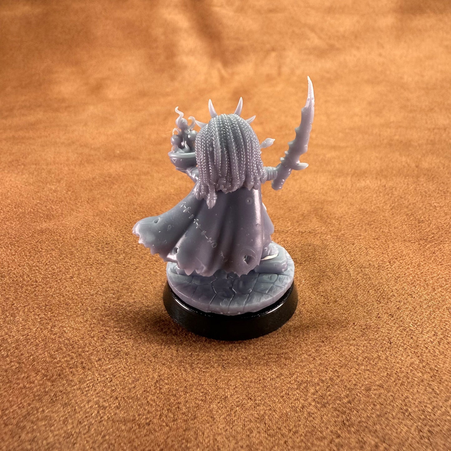 Gray fantasy figurine on a brown surface
