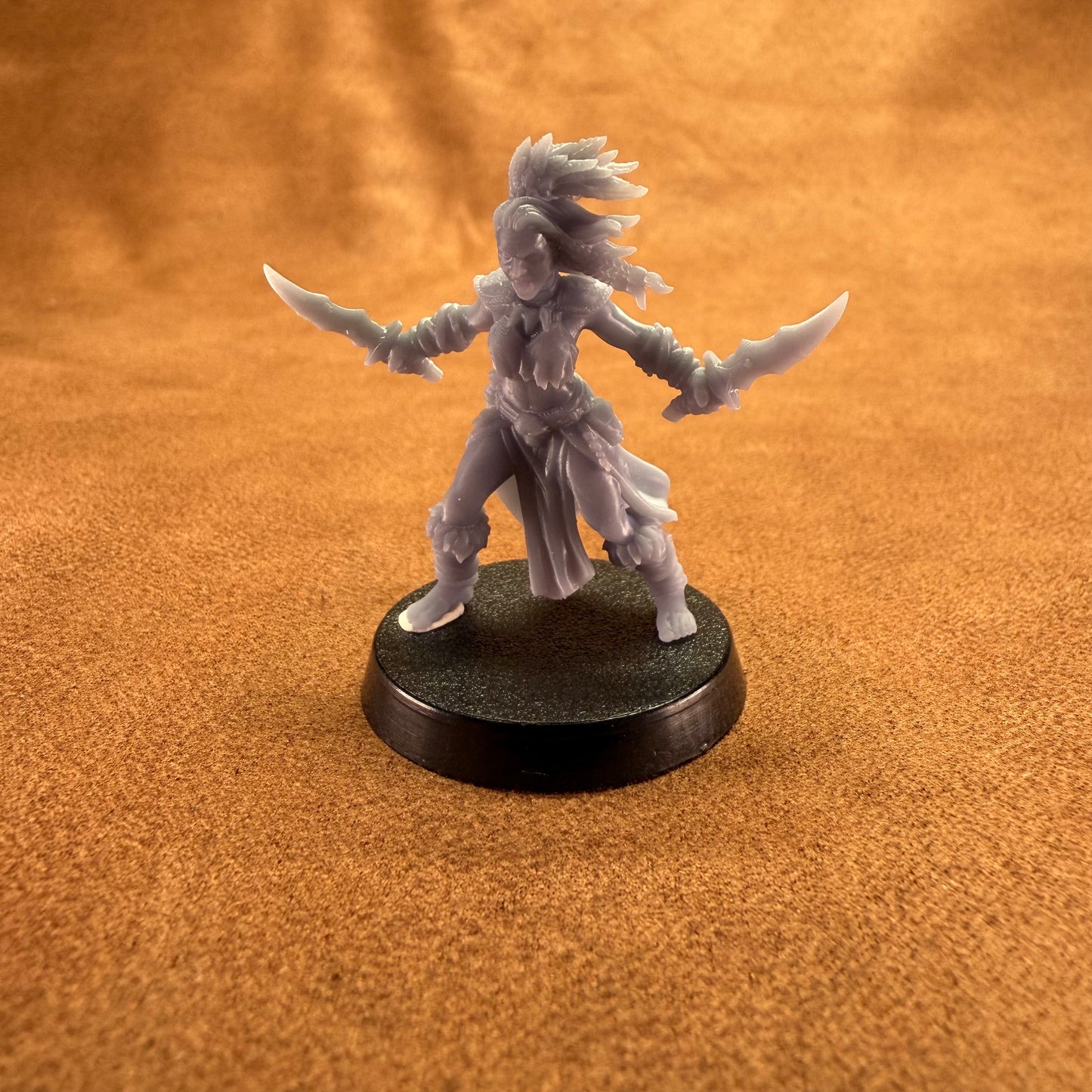 Fantasy figurine on a round base against an orange background