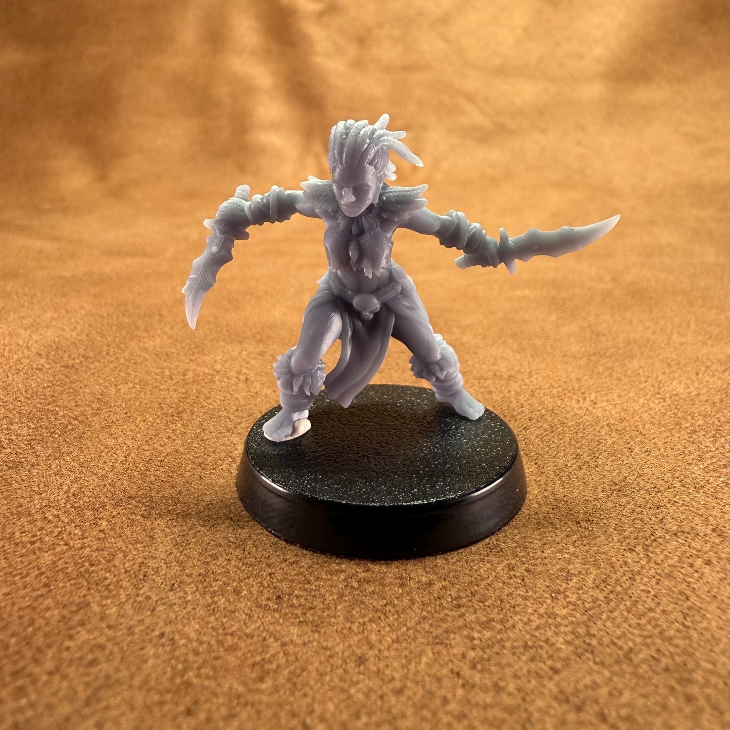 Gray fantasy figurine on a black base against a brown background