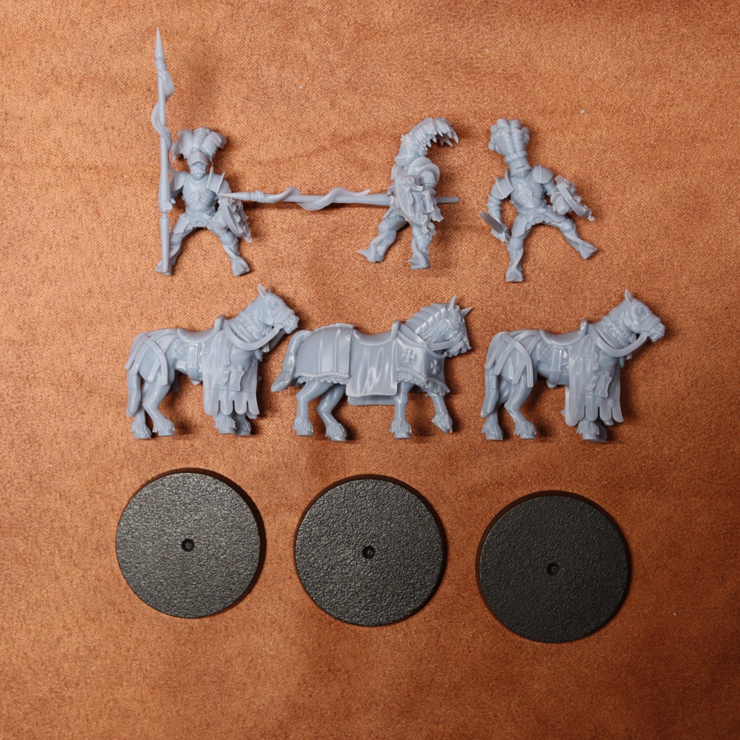 Set of gray plastic figures and horses on a brown surface