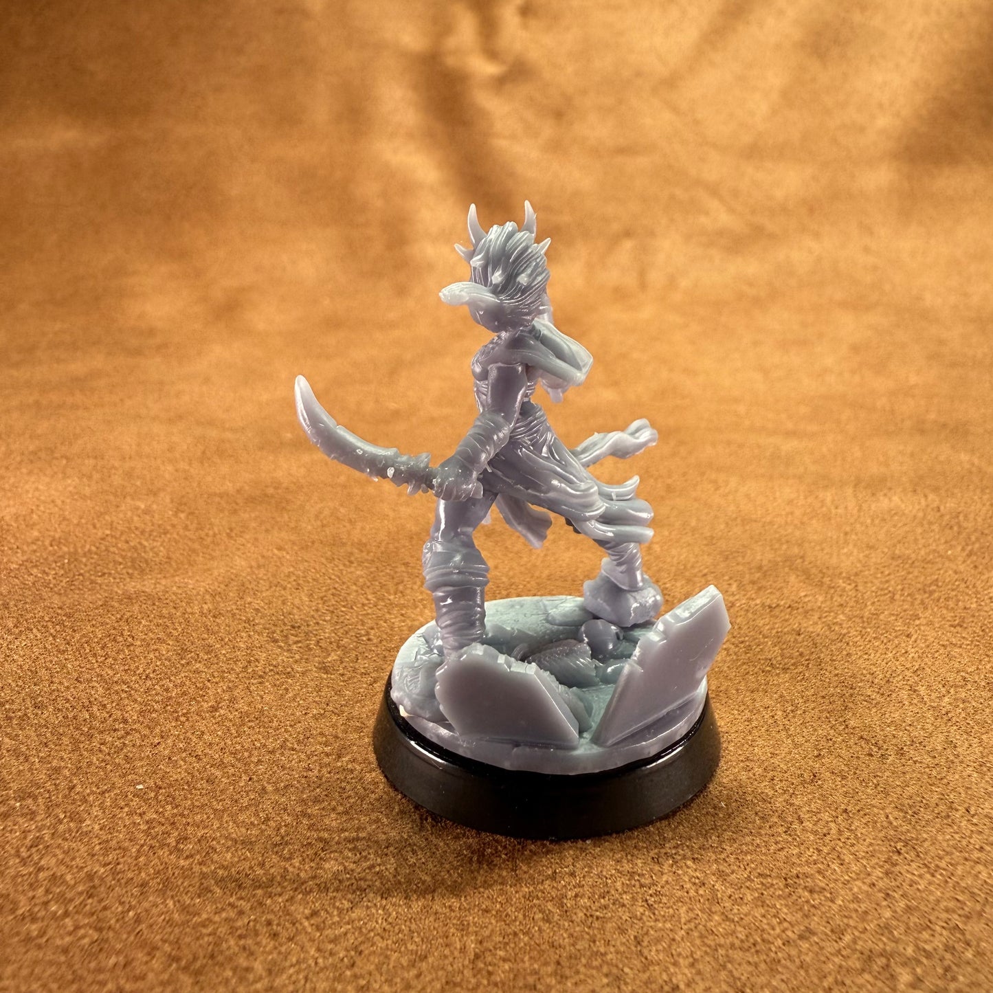 Fantasy figurine on a round base against a brown background