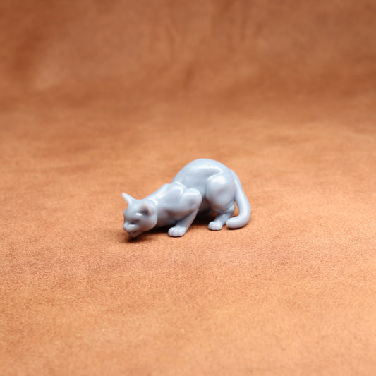 White cat figurine on a brown leather surface