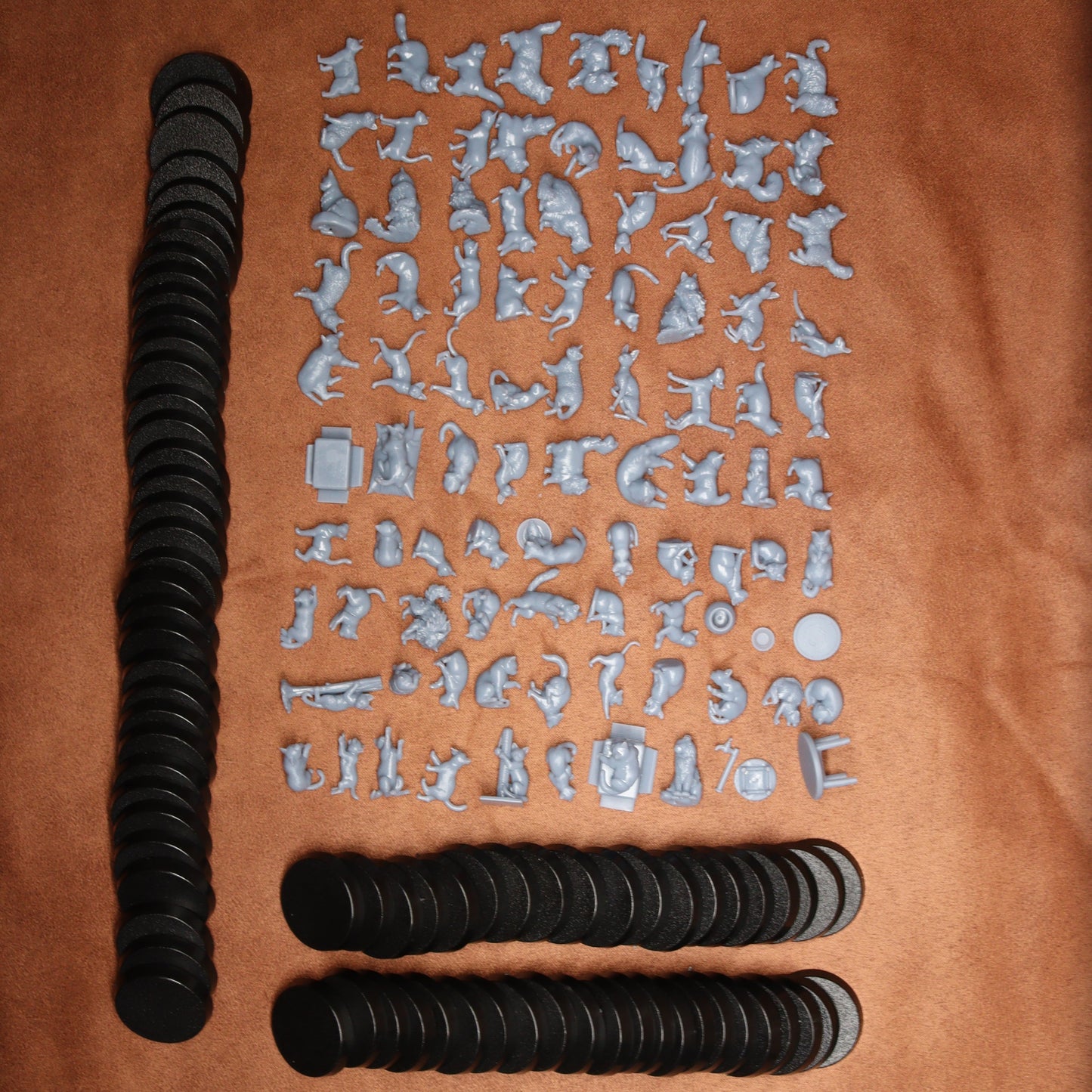 88 cats miniature figurines with black round bases on a brown background.