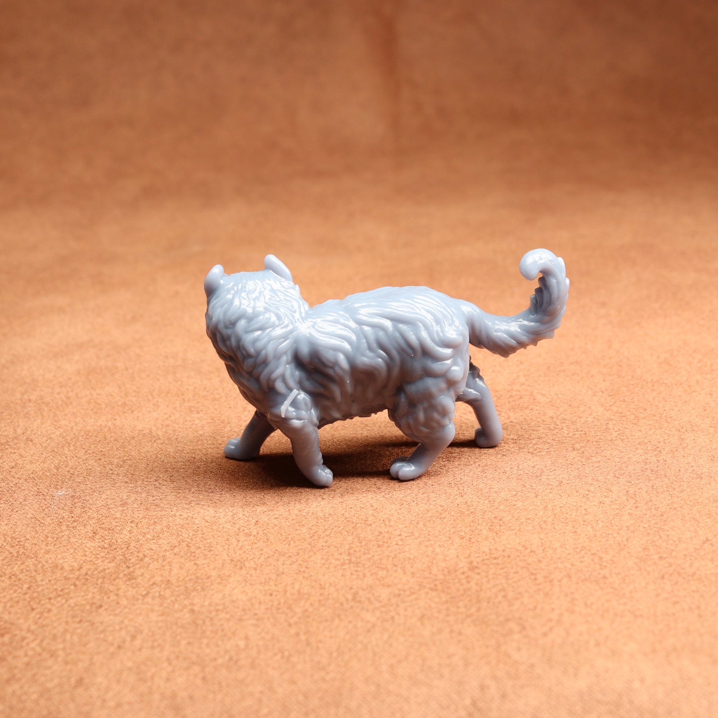 White 3D-printed cat figurine on a brown surface
