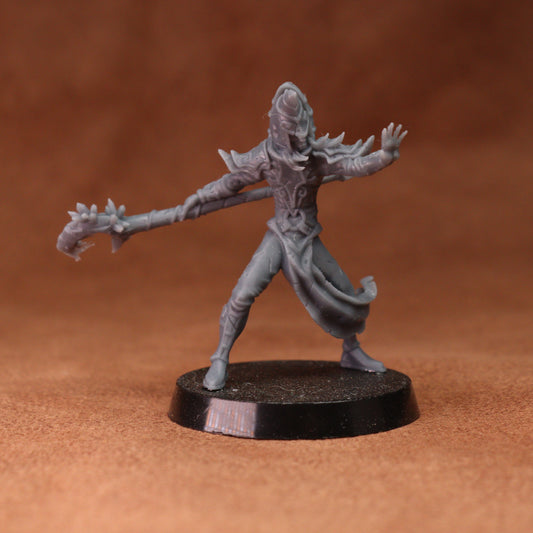 A gray unpainted fantasy miniature figurine of a warrior holding a spiked mace, standing on a round black base against a warm brown background.