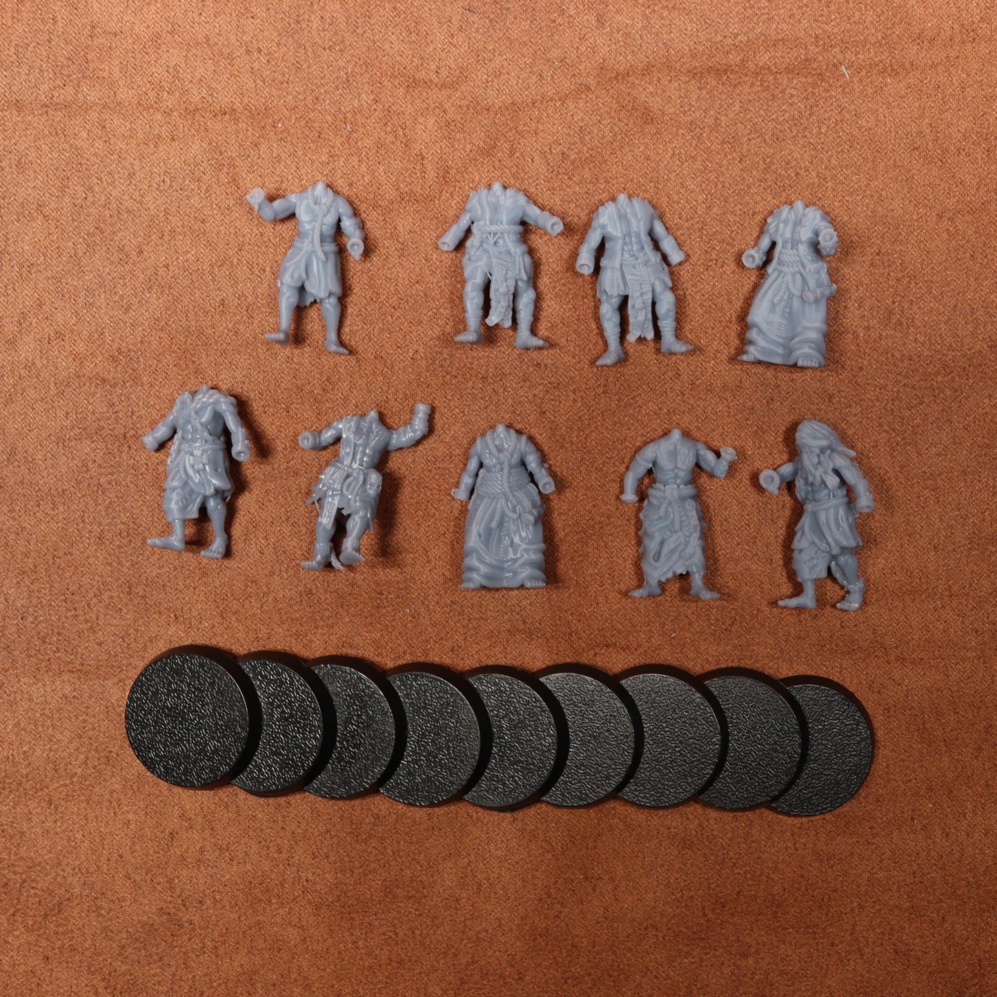 Set of miniature figures and round bases on a brown surface