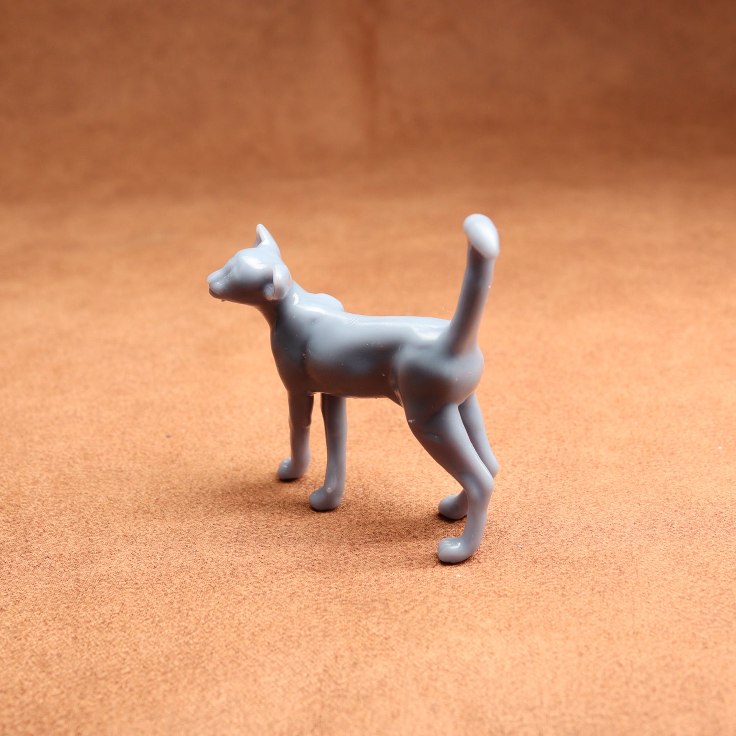 Gray cat figurine on a brown surface