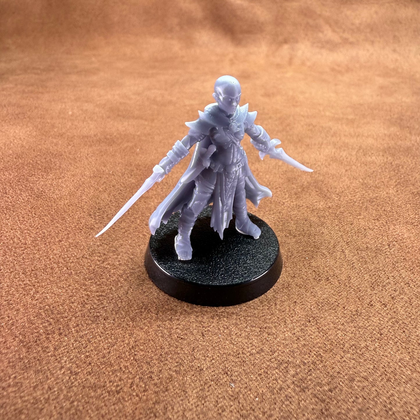 White fantasy figurine on a black base against a brown background