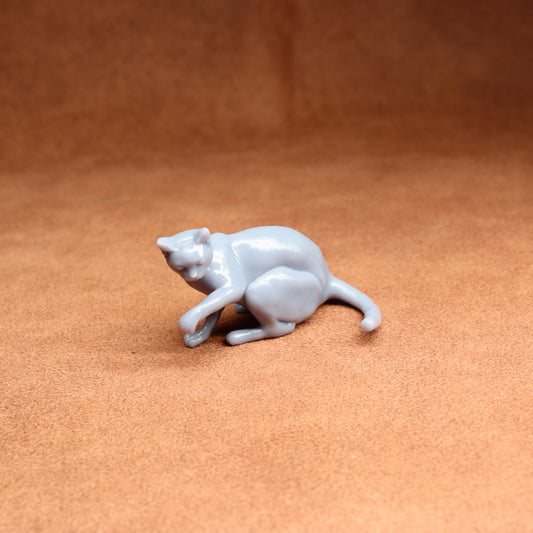 White ceramic cat figurine on a brown surface
