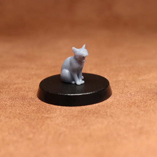 grey cat resin miniature on a black base on a brown background.