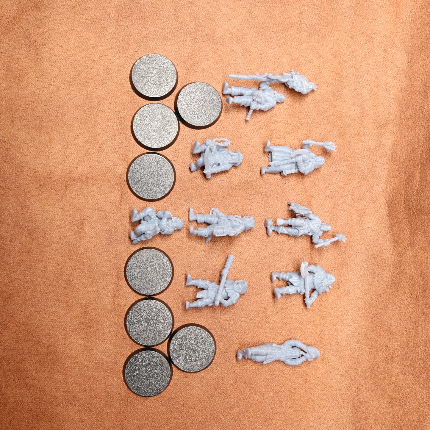 Small scale model figures and round metallic objects on a brown surface