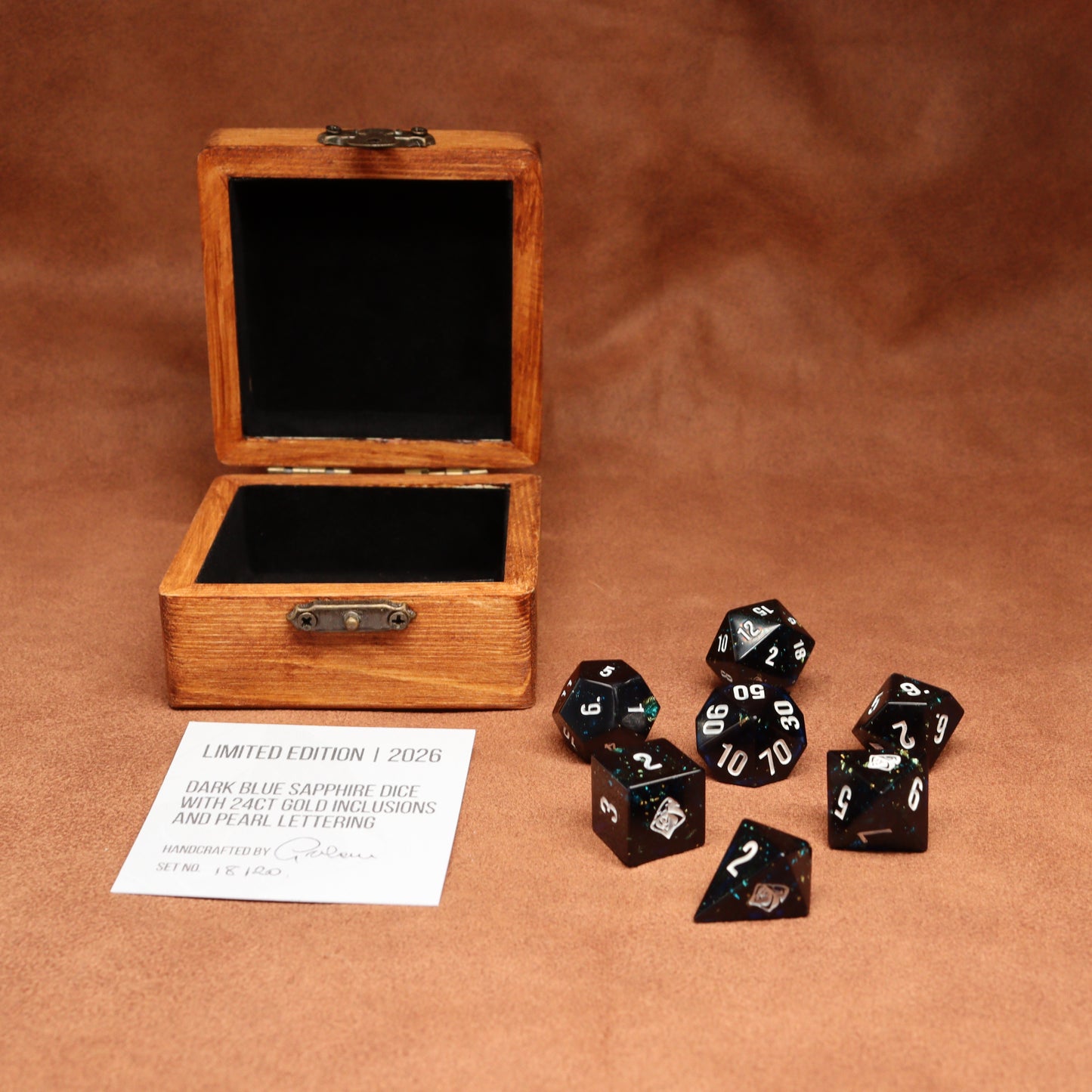 Wooden box with dark blue sapphire dice on a brown background