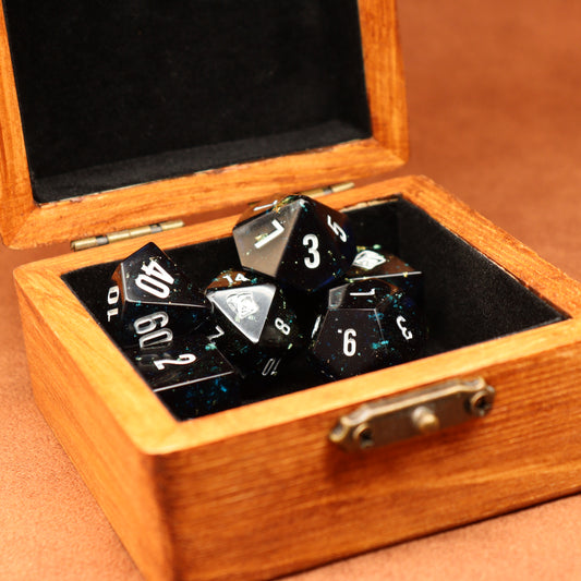 Set of polyhedral dice in a wooden box on a brown surface