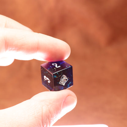 Hand holding a small dice with starry design against a blurred brown background