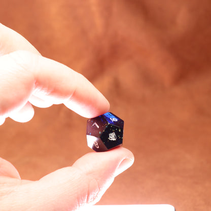 Hand holding a blue and black die against a brown background