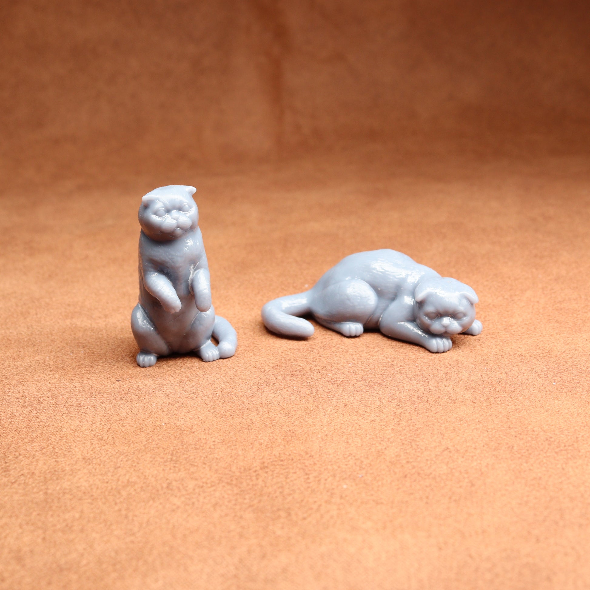 Two small white animal figurines on a brown surface