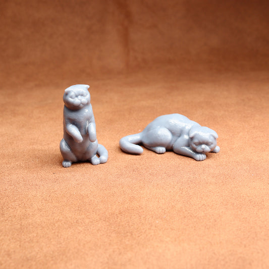 Two small white animal figurines on a brown surface