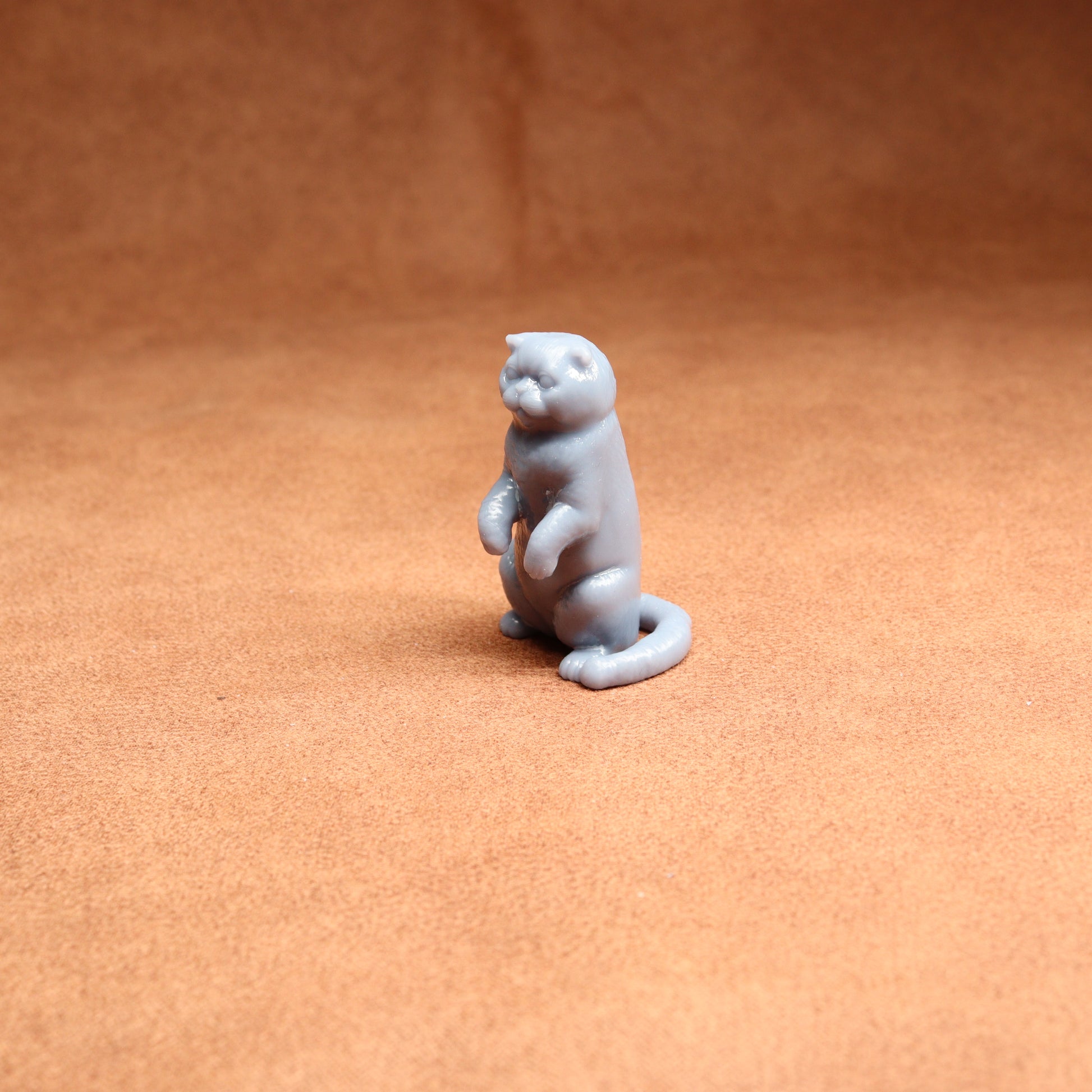 Gray cat figurine on a brown surface
