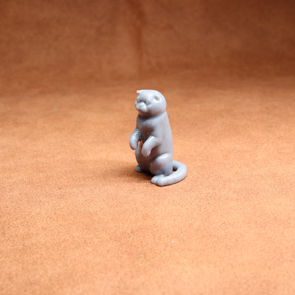 Gray cat figurine on a brown surface