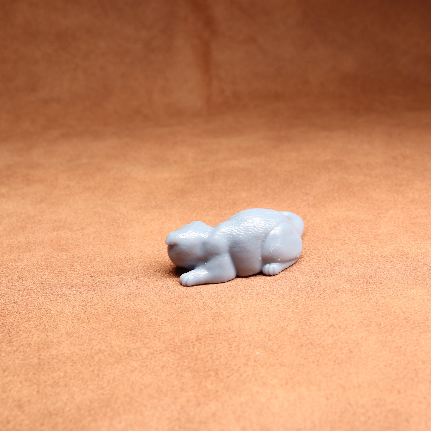 Small white figurine of a bear on a brown surface