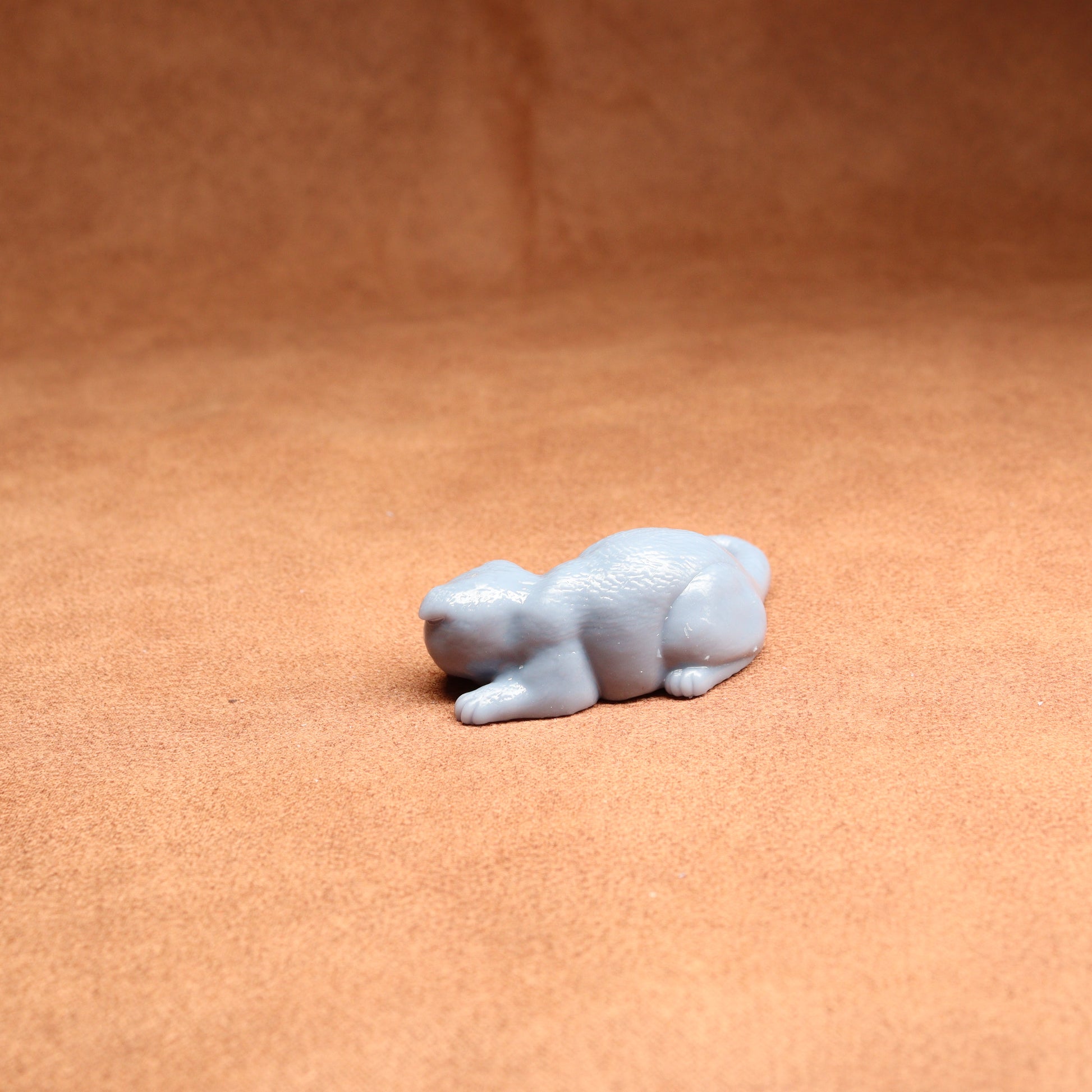 Small white figurine of a bear on a brown surface