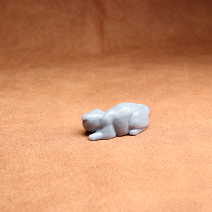 Small white figurine of a bear on a brown surface