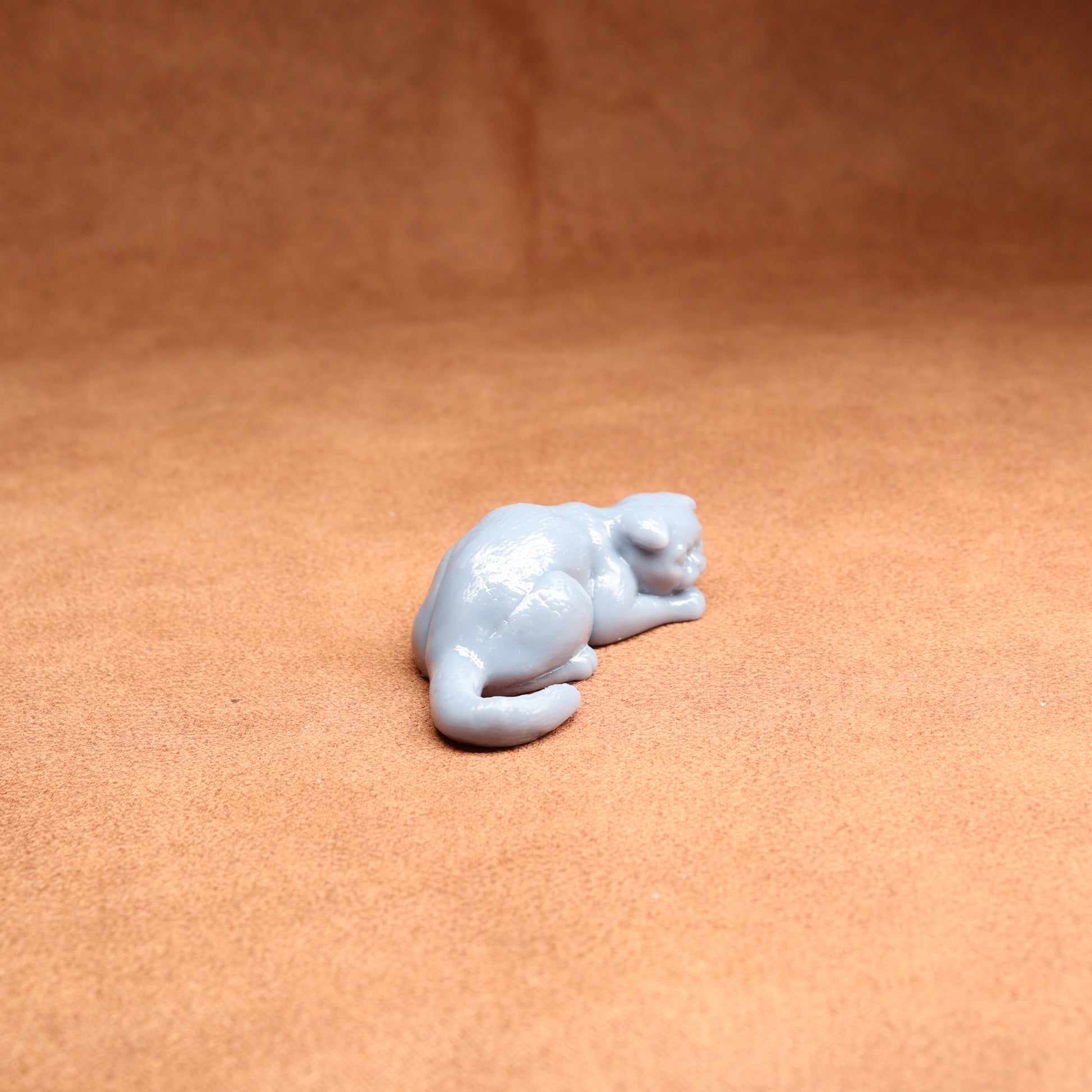 White ceramic cat figurine on a brown surface