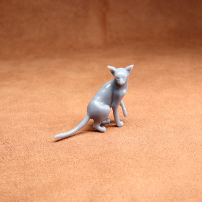 Gray cat figurine on a brown surface