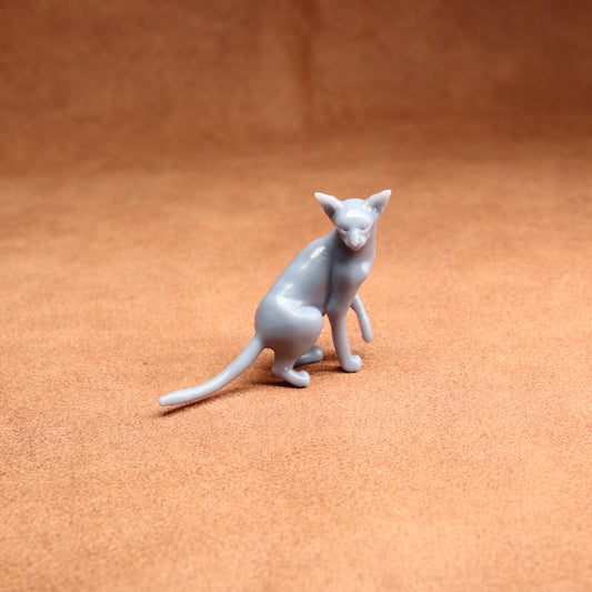 Gray cat figurine on a brown surface