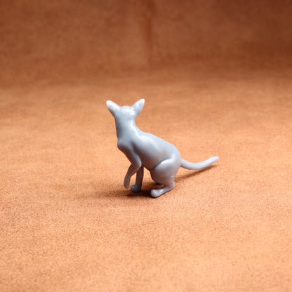 White plastic kangaroo figure on a brown surface