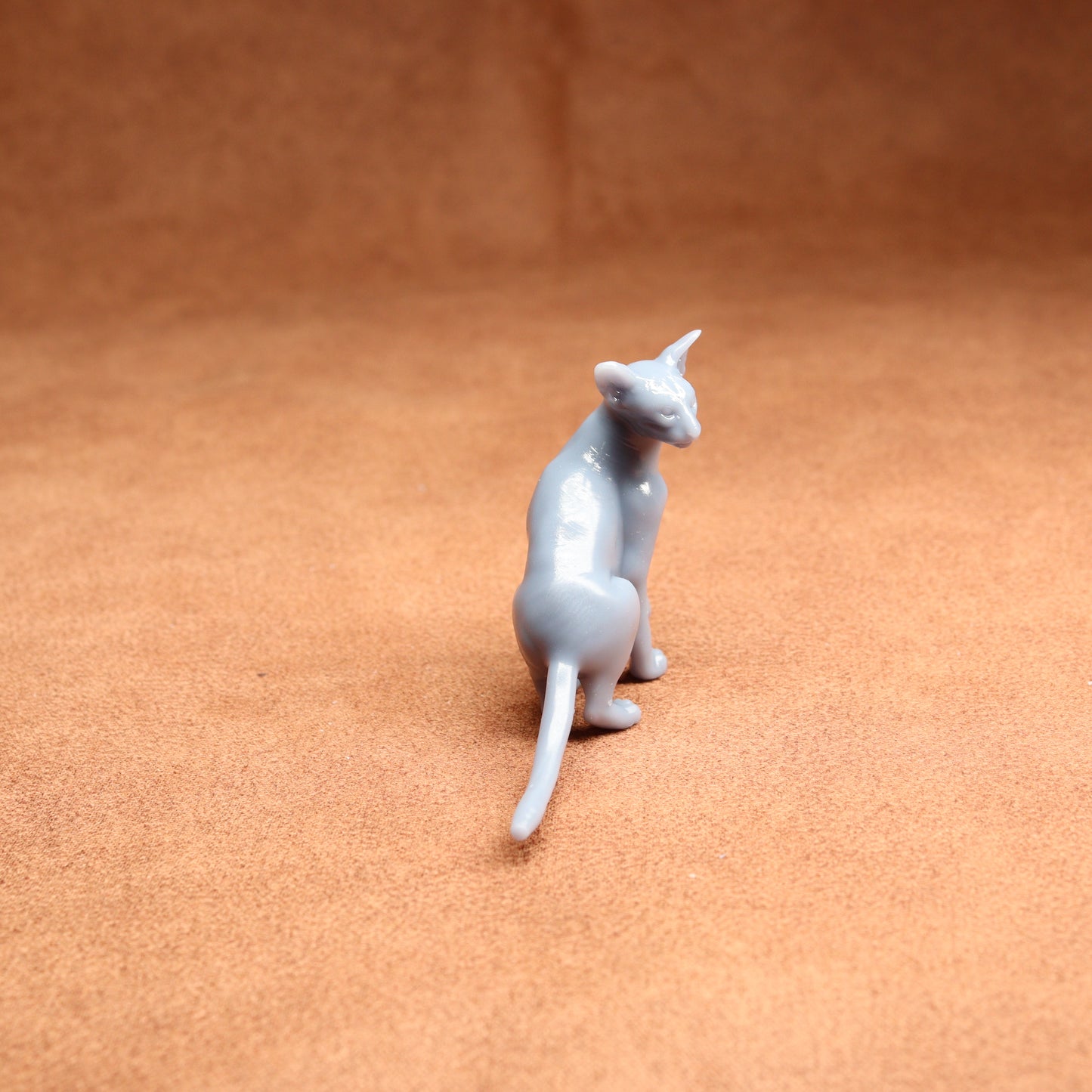 Gray cat figurine on a brown surface