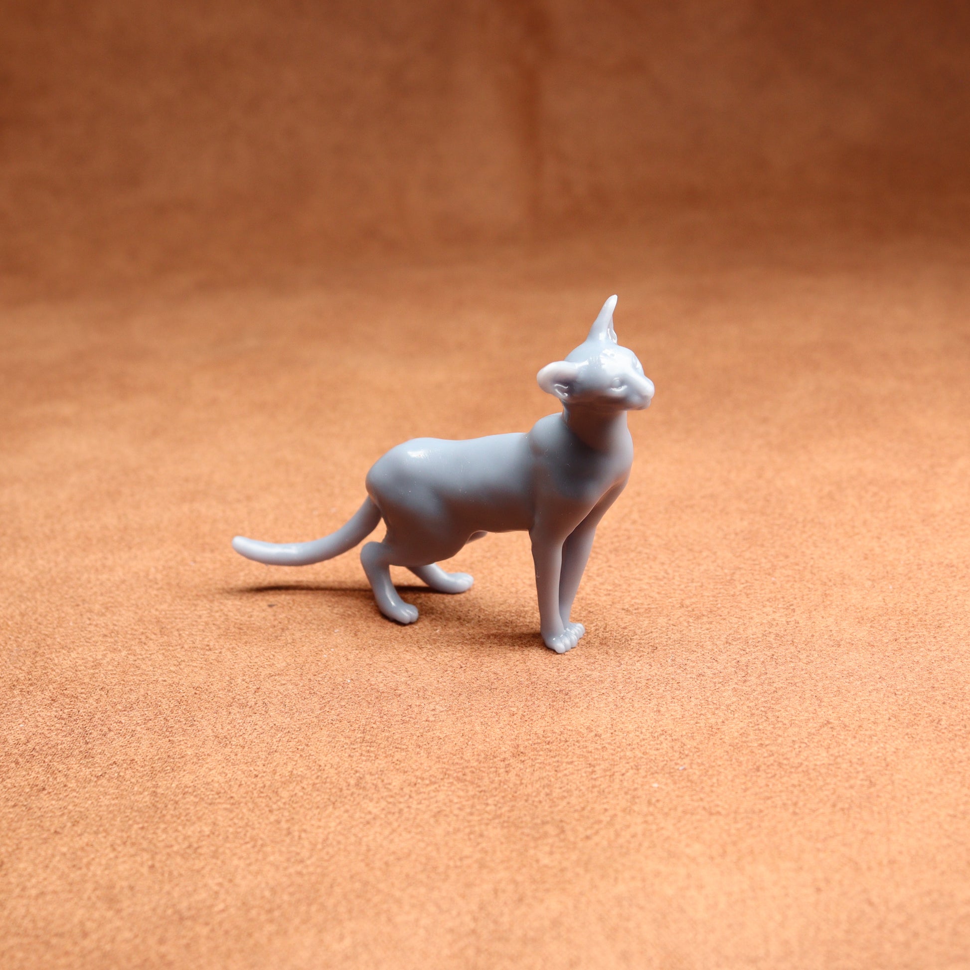Gray cat figurine on a brown surface
