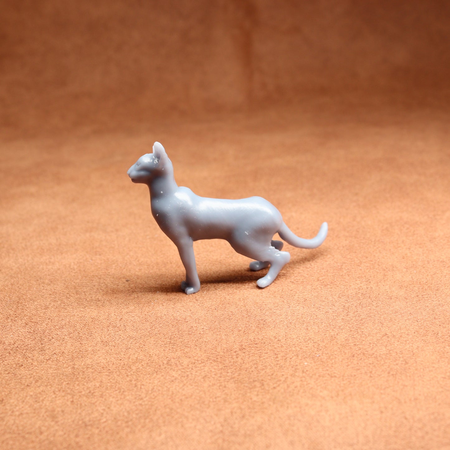 Gray toy dog figure on a brown surface