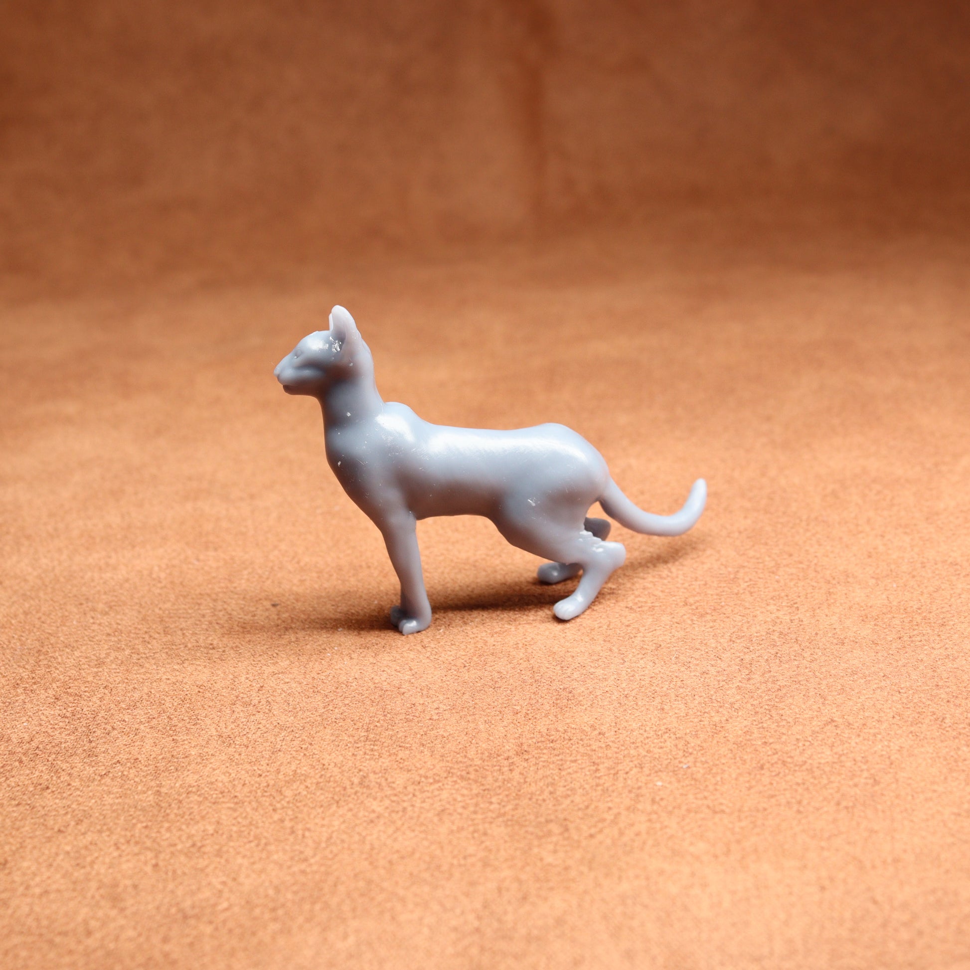 Gray toy dog figure on a brown surface