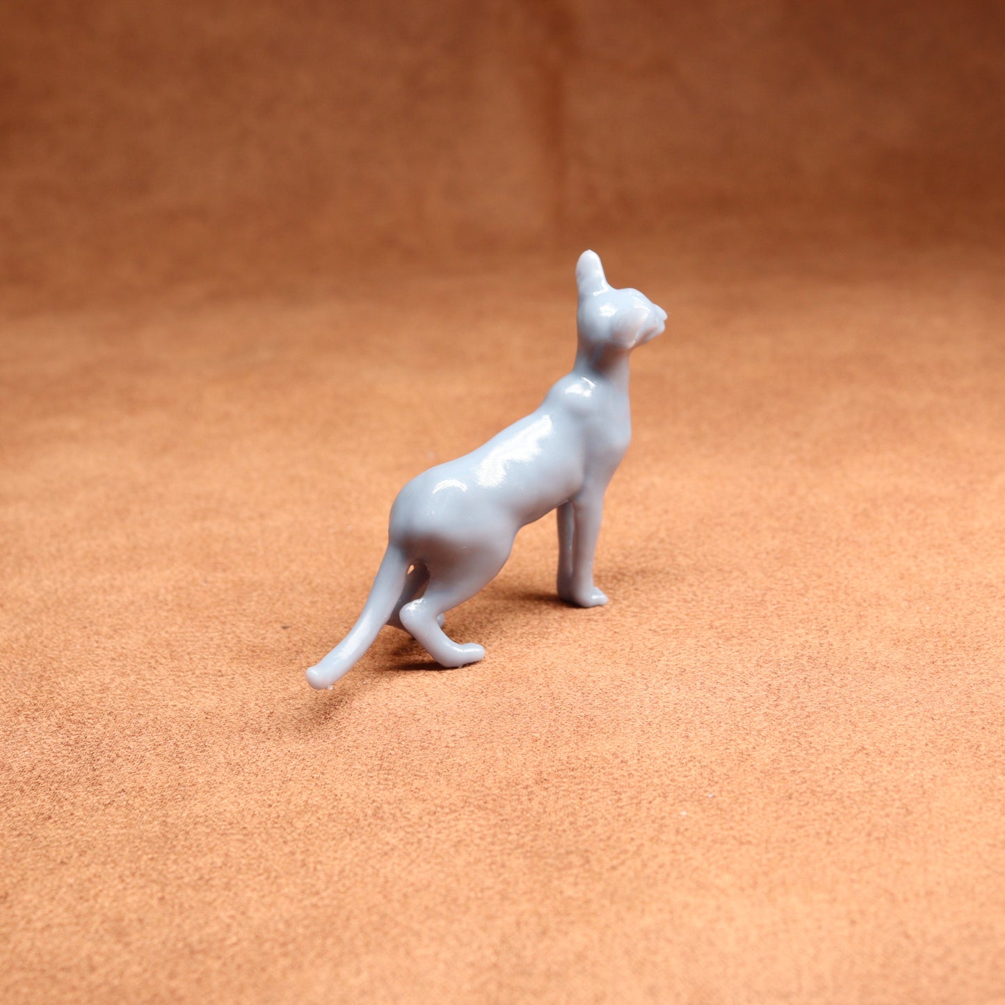 White ceramic cat figurine on a brown surface