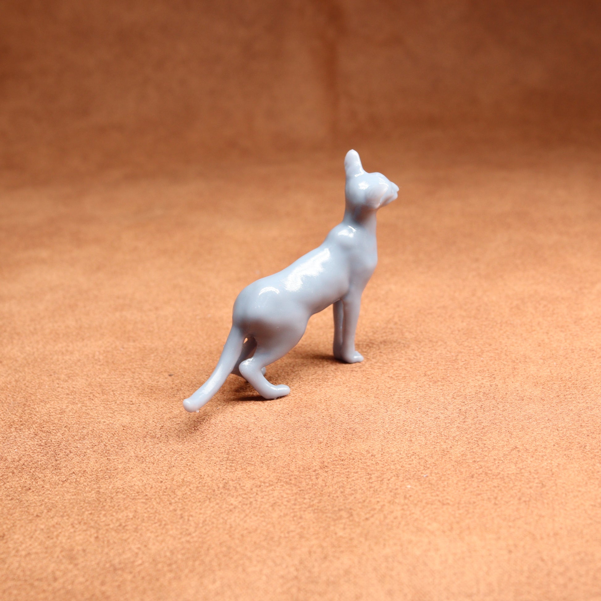 White ceramic cat figurine on a brown surface