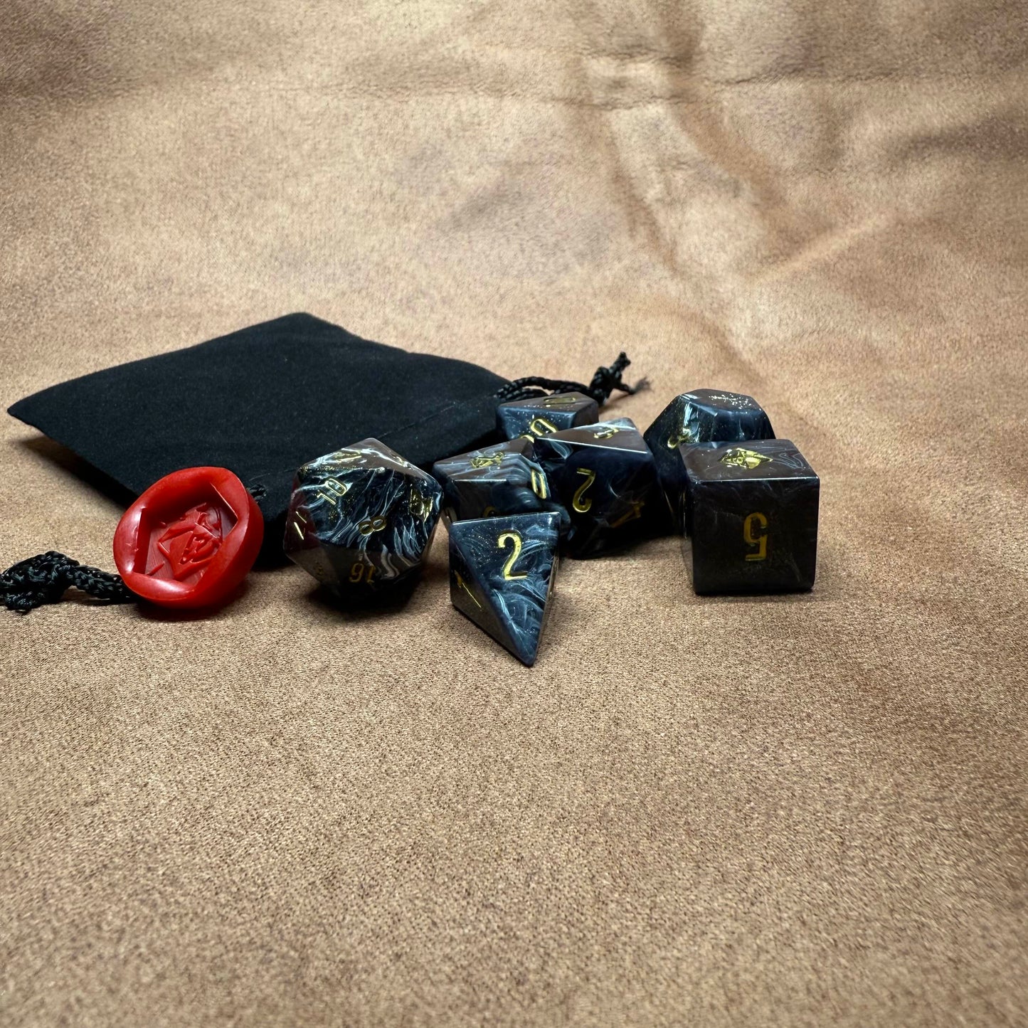 Set of dice with a black pouch on a beige surface