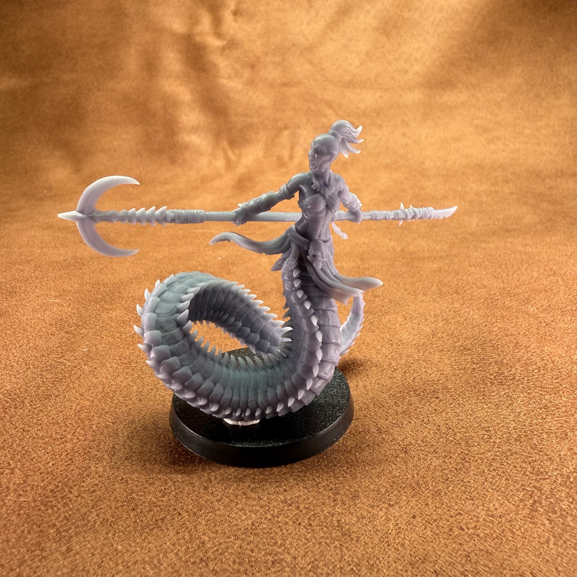 Fantasy figurine of a creature with a spear on a brown textured background