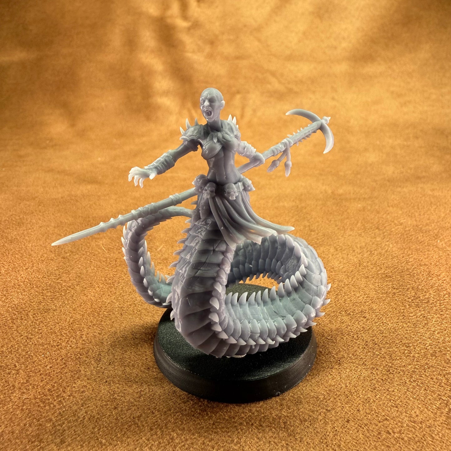 Fantasy figurine of a creature with a dragon-like tail on a brown surface