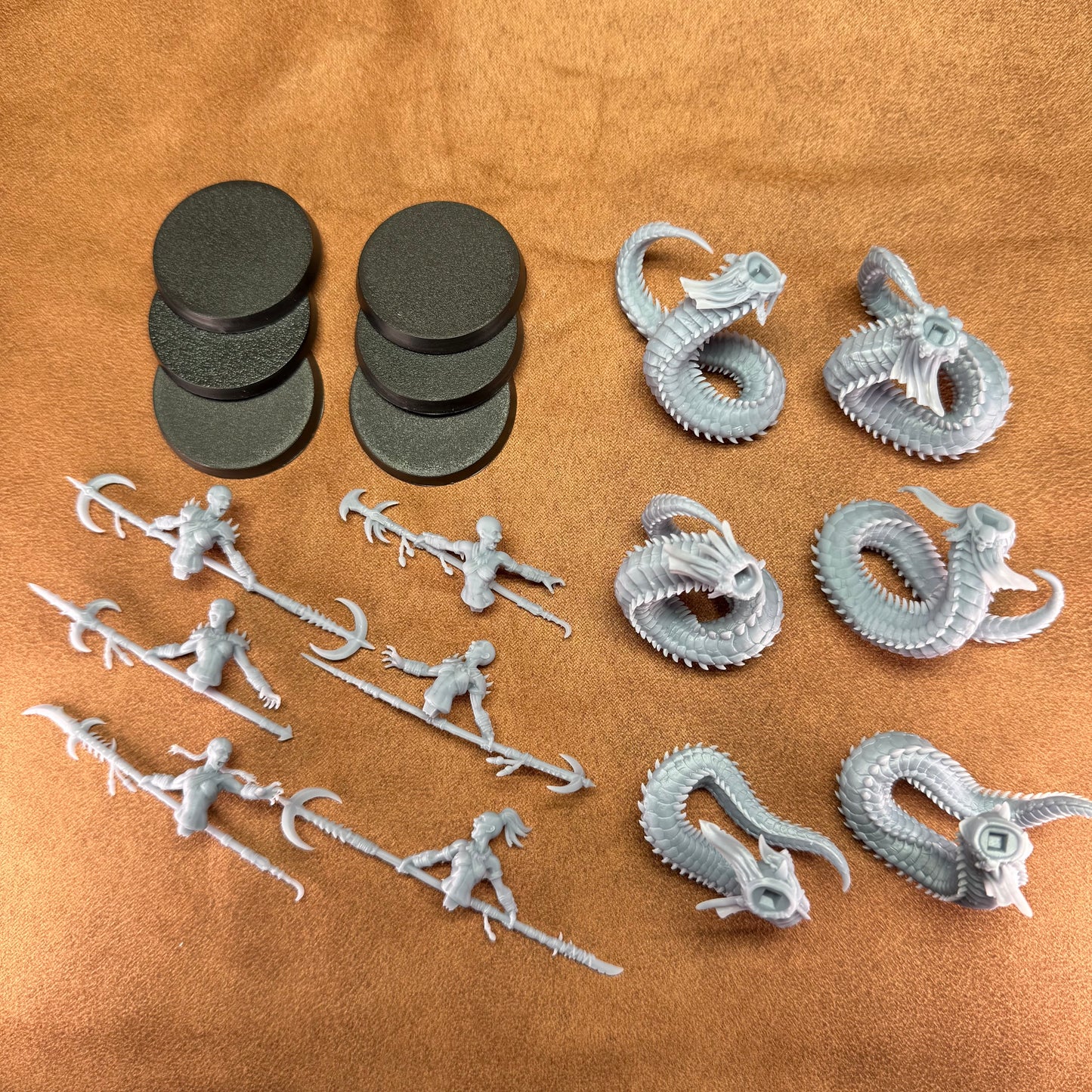 Collection of gray plastic figurines and dragon models on a brown surface