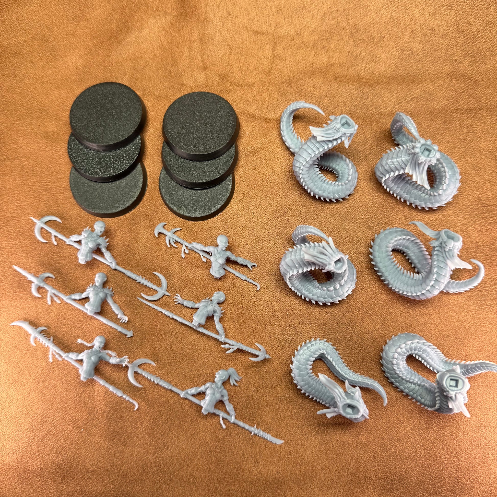 Collection of gray plastic figurines and dragon models on a brown surface