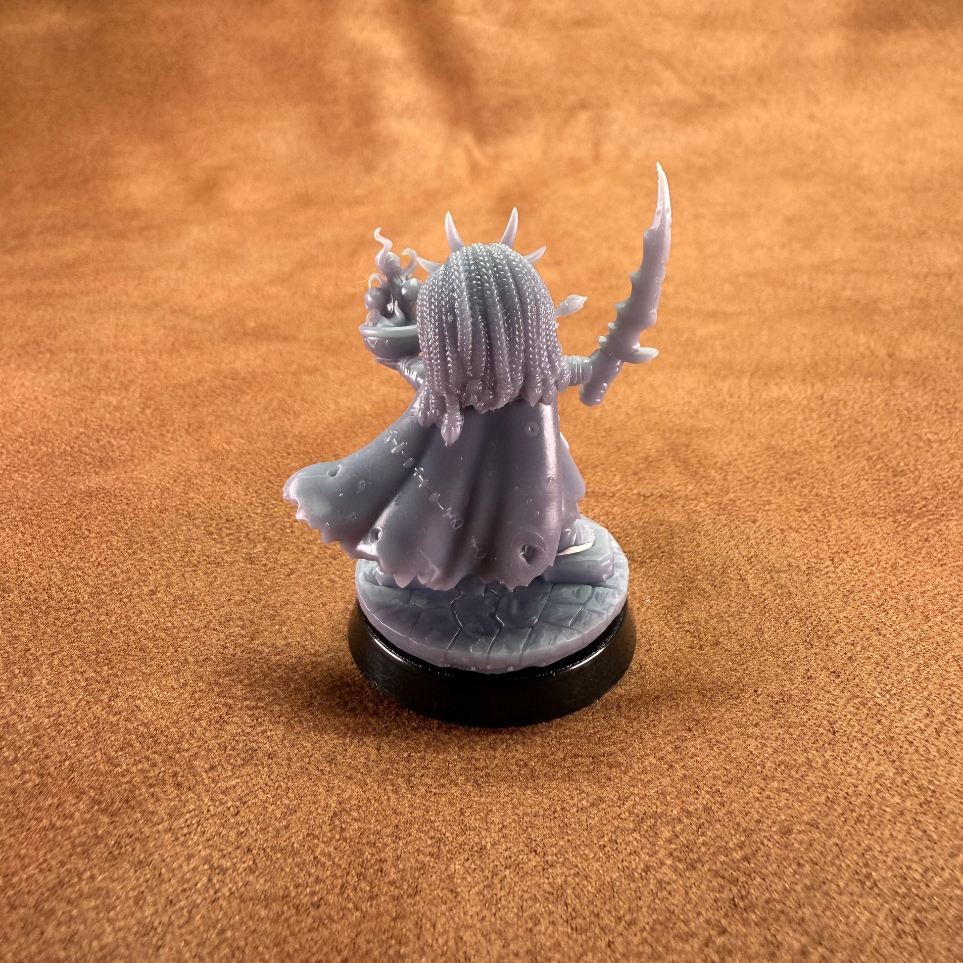 Gray fantasy figurine on a brown surface