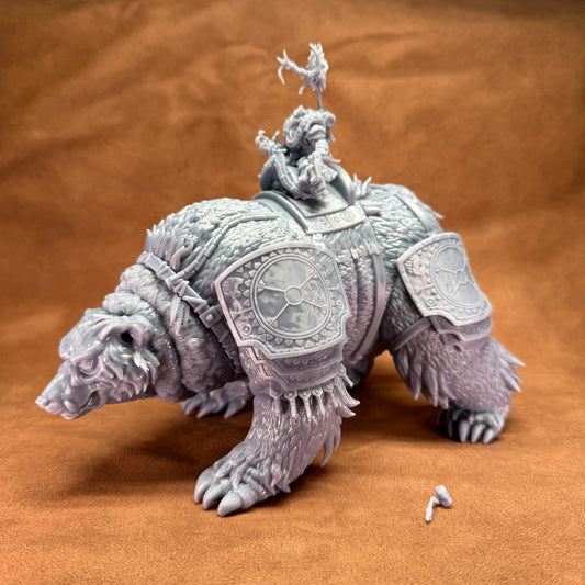 Statue of a bear with armor and a figure on its back against a brown background