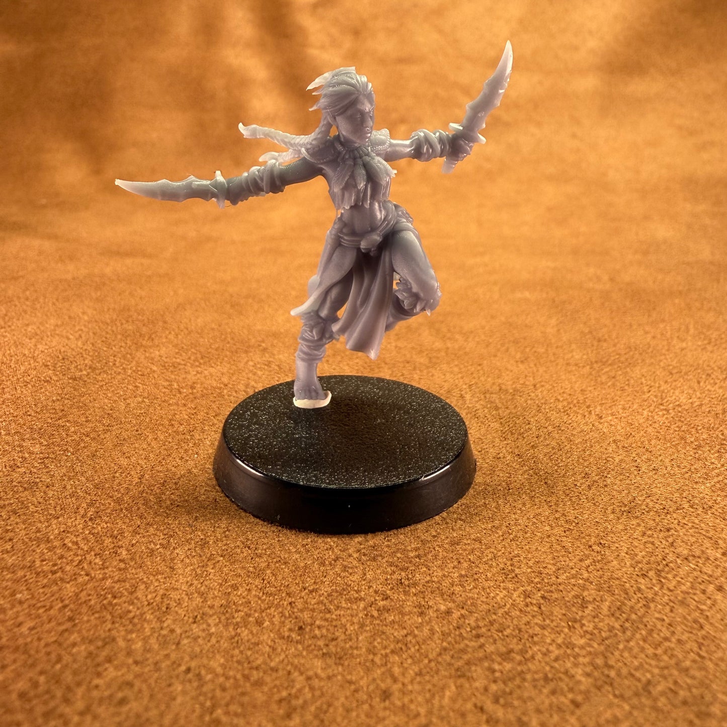 Fantasy figurine on a round black base against an orange background