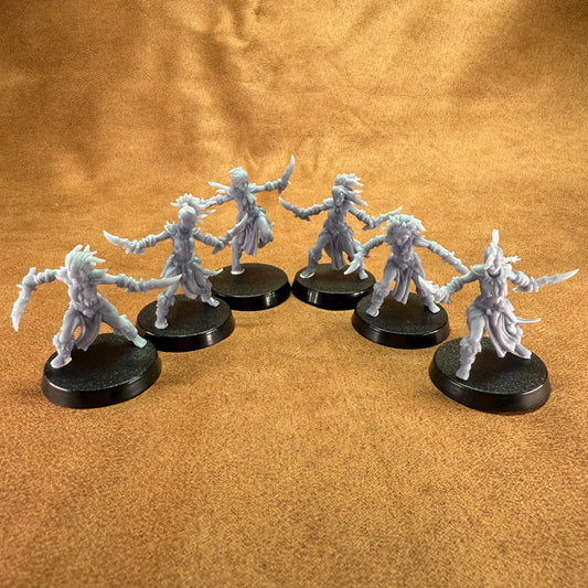 Six fantasy miniature figures on black round bases against a brown background