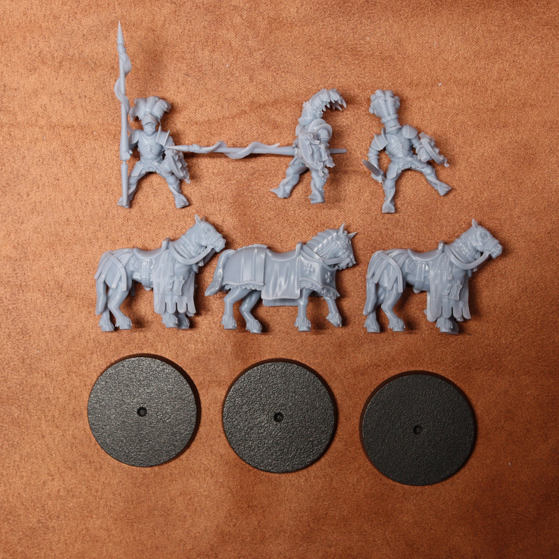 Set of gray plastic figures and horses on a brown surface