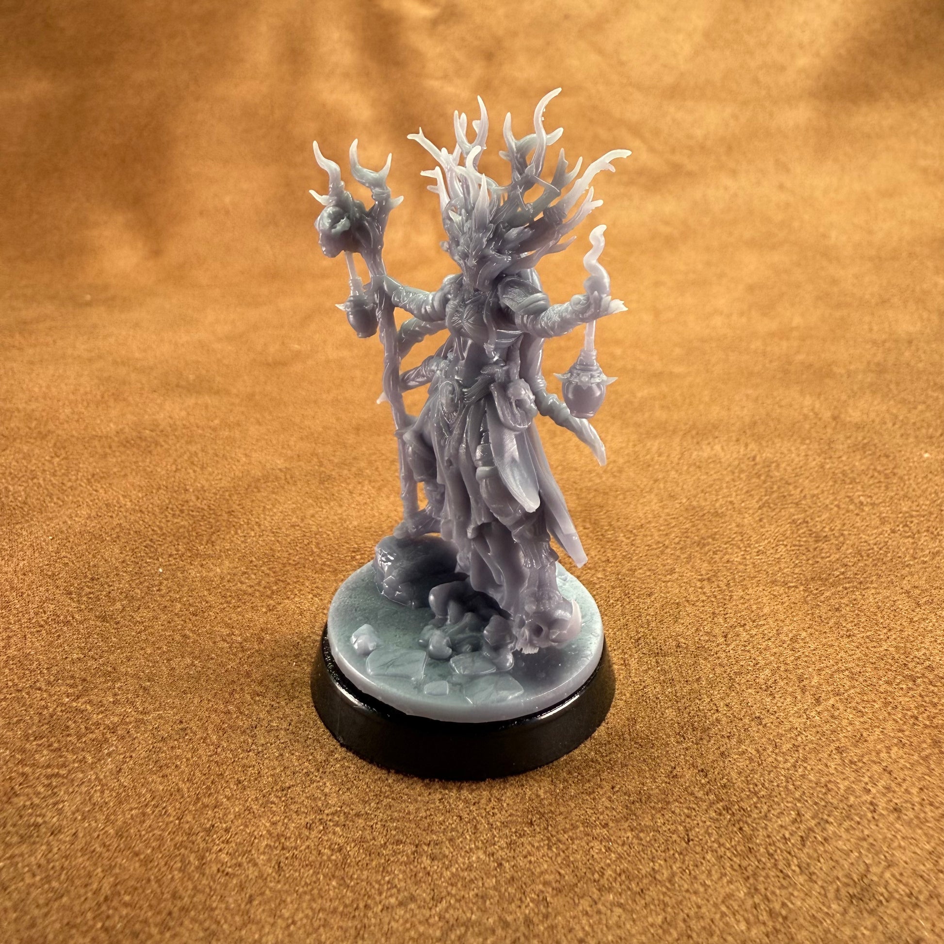 Fantasy figurine on a round base against a brown background