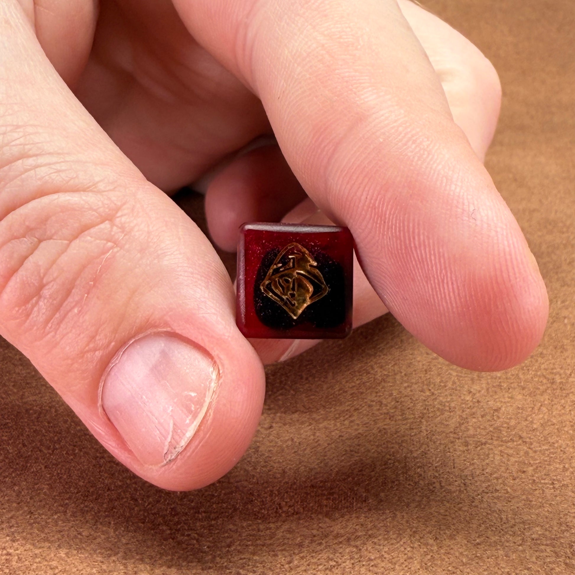 Red and black dice with rogue emblem and gold ink