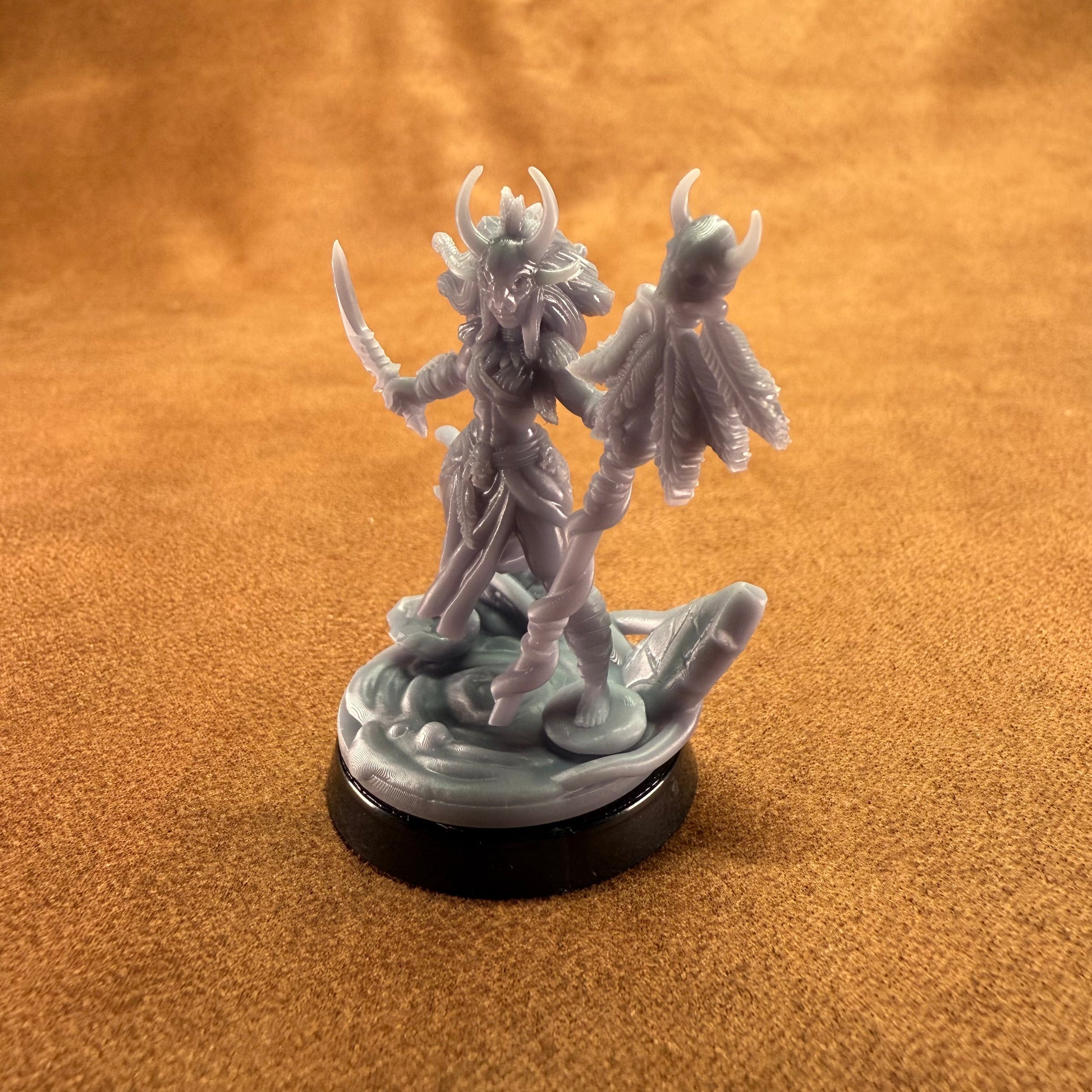 Fantasy figurine on a round base against an orange background