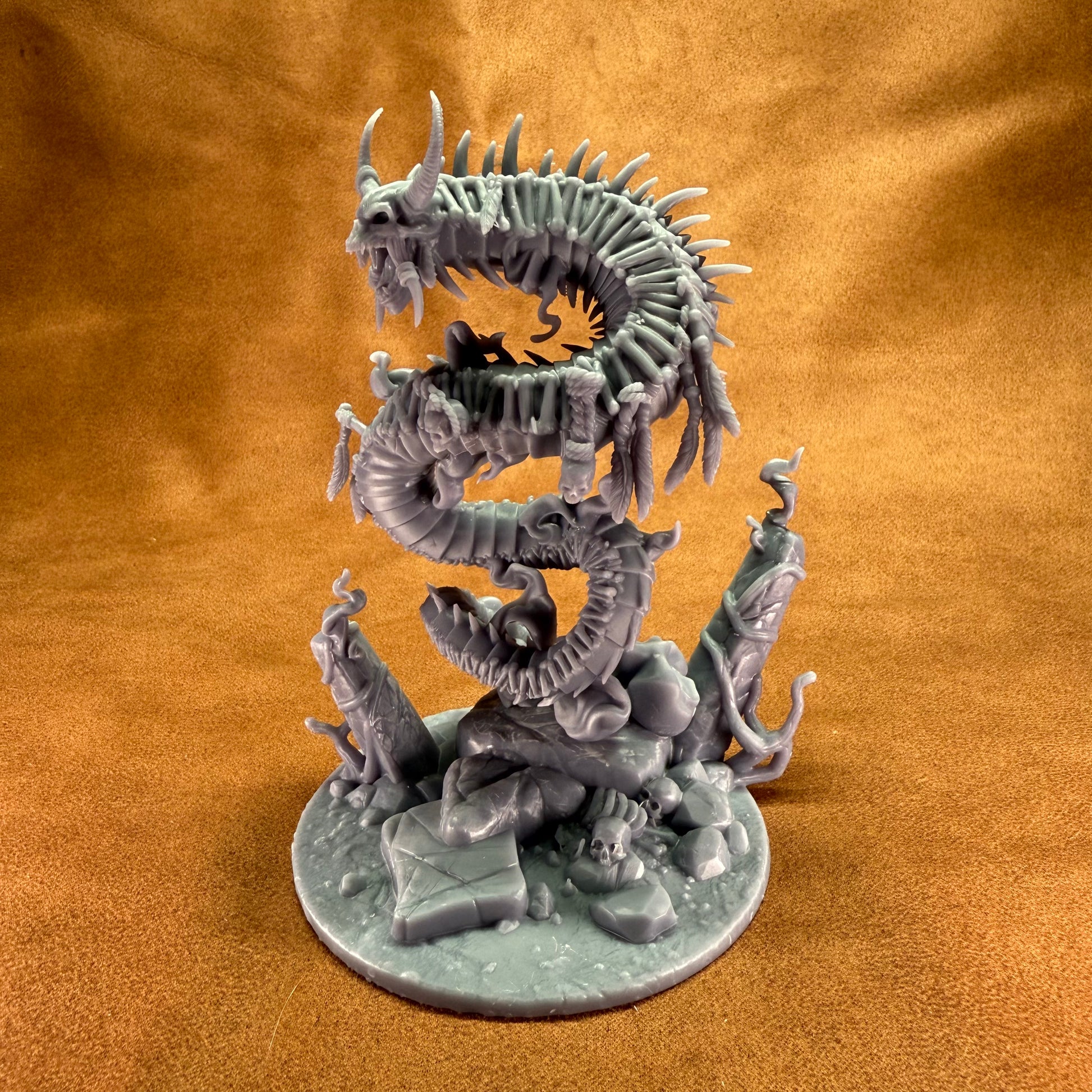 Dragon-like creature figurine on a round base against a brown background